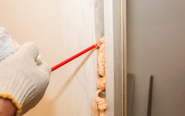 Mousse isolante pour porte appliquée autour du cadre.
