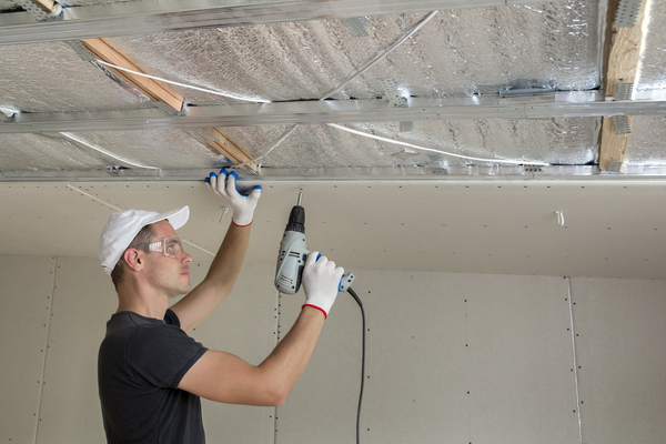 Pose de plaques d'isolant pour plafond par vissage.