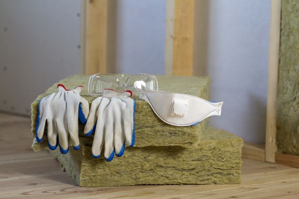 Type d'isolant minéral en plaque semi-rigide avec des gants placés dessus.